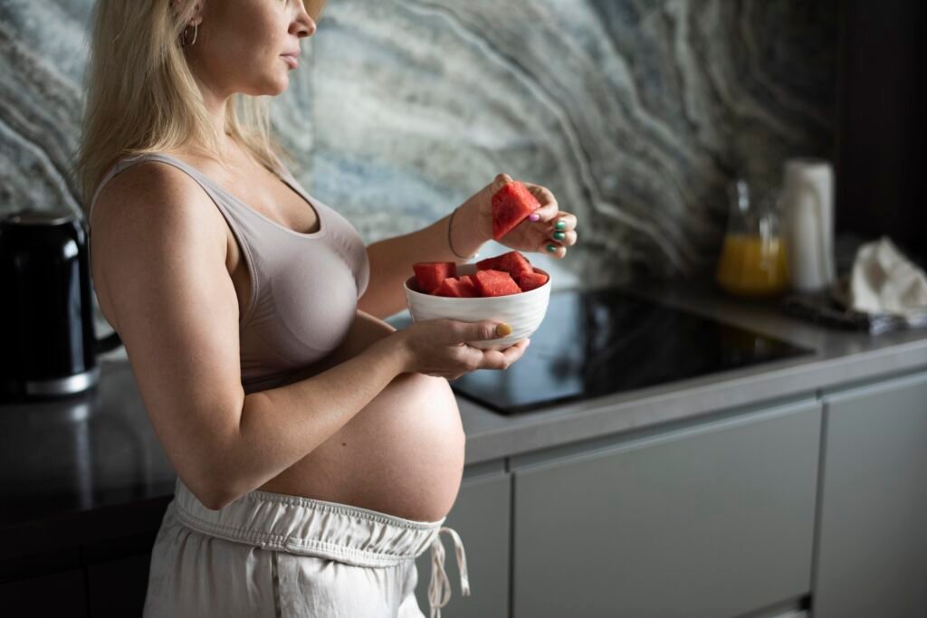 Mulher grávida comendo uma tijela de frutas